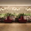 A restaurant with red chairs and plants on the wall